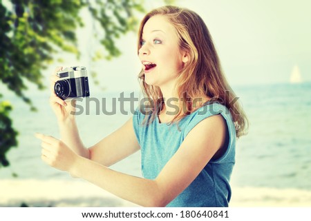 Pretty girl making photo using classic slr camera.