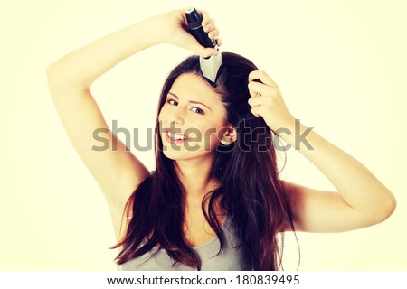 Young woman cutting her long hairs with hair clipper