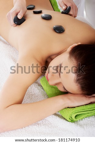 Beautiful woman lying on spa salon having stone massage. Spa concept.