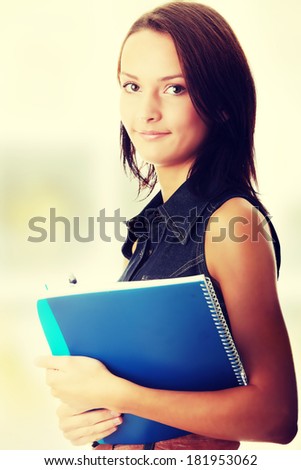 Female university student smiling and carrying some notebook