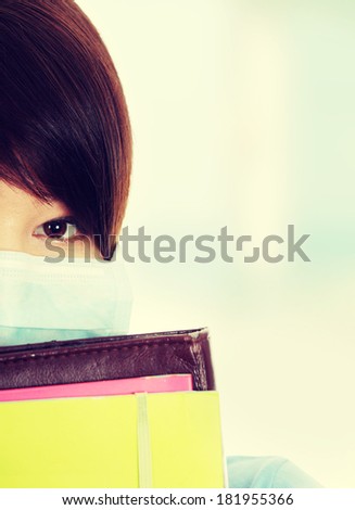 Close up portrait of young  student woman with mask on her face. She is defending her self from viruses.