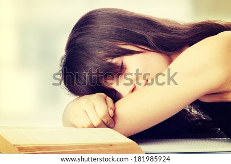Sleeping while learning - tired teen woman sleeping on desk