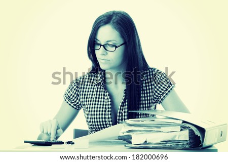 Female executive filling out tax forms while sitting at her desk.