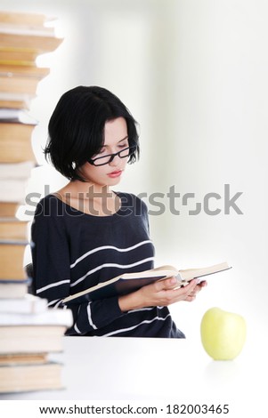 Young student woman with books studying at the desk