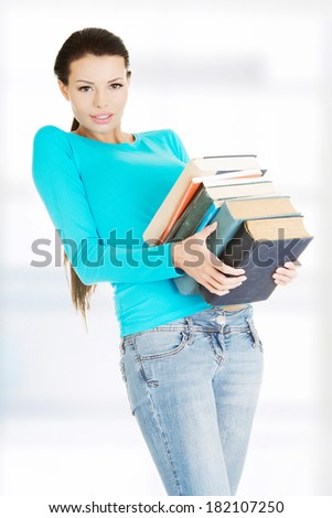 Student woman holding heavy books