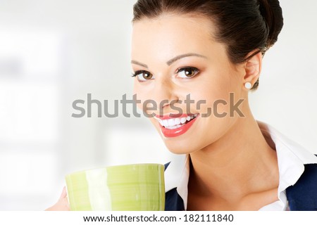 Smiling businesswoman having coffee / tea break
