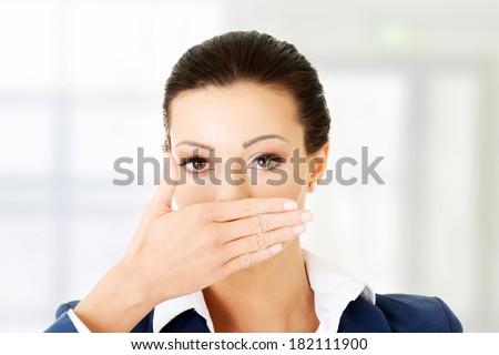 Portrait of young business woman covering with hand her mouth