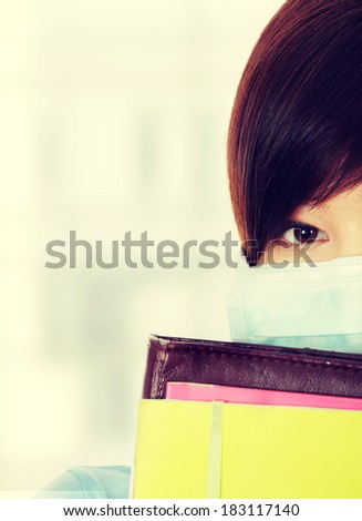 Close up portrait of young  student woman with mask on her face. She is defending her self from viruses.