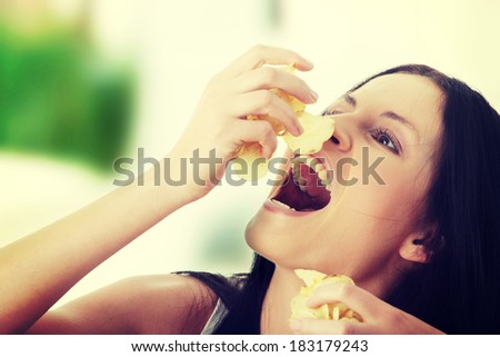 Young beautiful woman eating chips