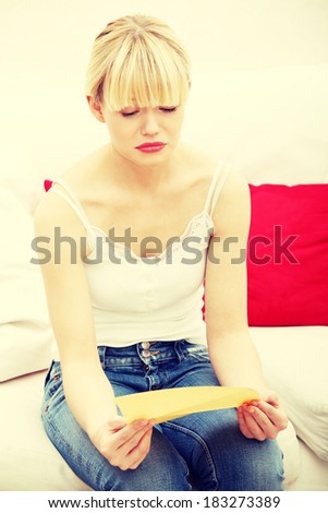 Worried woman\'s reading letter, at home.