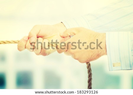 Businessman pulling on a piece of rope.