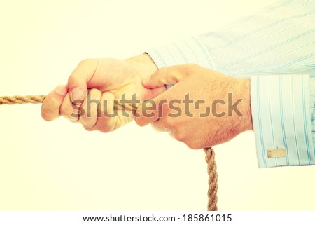Businessman pulling on a piece of rope.