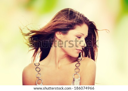 Young beautiful woman in elegant, evening, white dress dancing with wind (hair blowing)