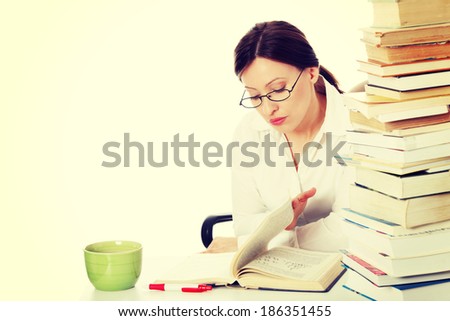 Mature student woman is learning at the desk , against white background