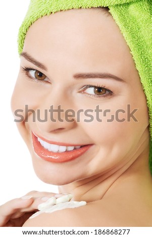 Beautiful woman applying body lotion on arm. Spa concept.