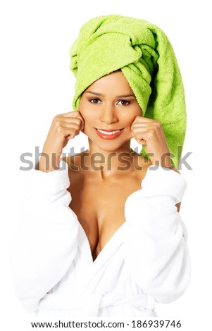 Attractive woman wrapped in towel, holding her mouth in a smile. Isolated on white.