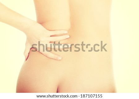 Close up on female\'s lower back. She\'s touching them.