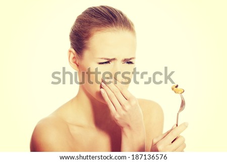 Young caucasian woman eating seafood with disguise. Isolated on white.