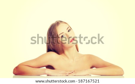 Beautiful caucasian naked woman lying on a table. Isolated on white.
