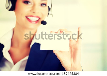 Smiling customer service representative with headset holding a blank empty card.