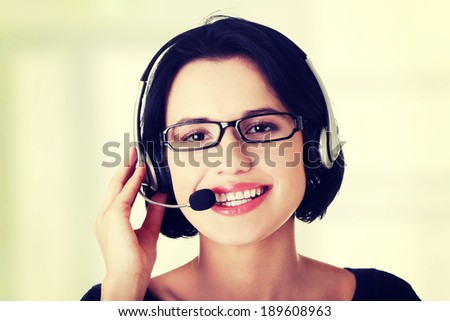 Closeup of attractive customer support representative smiling with headset on white background