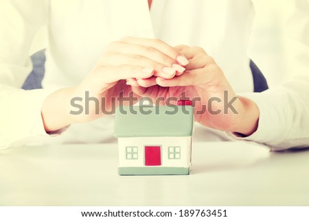 Female businesswoman hands protecting house. Home protecting concept for insurance or security