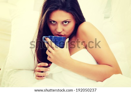 Beautiful lady is drinking coffee at bed