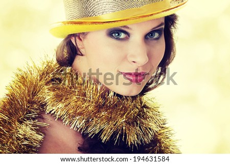 Young beautiful caucasian woman in black elegant party dress and gold hat
