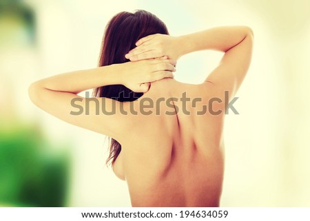 Nude woman from behind. Back pain concept.