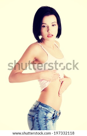 Young beautiful woman checking her fit belly