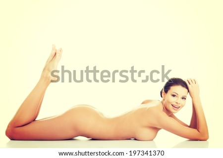 Beautiful happy  naked woman with fresh clean skin lying on belly