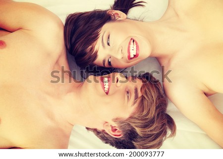 Beautiful young couple lying in bed.