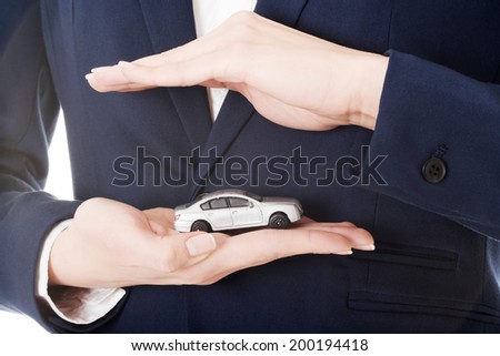 Close up on car toy model on woman\'s hand over her belly and formal clothes.