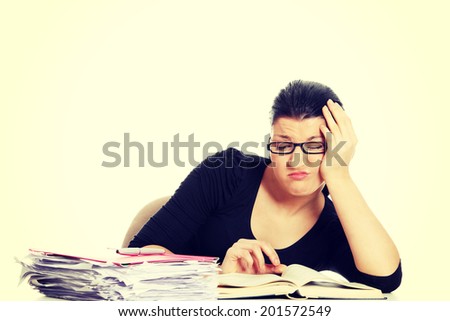 Woman filling out tax forms while sitting at her desk.