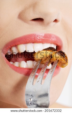 Smiling caucasian woman eating sea fruit with fork. Isolated on white.