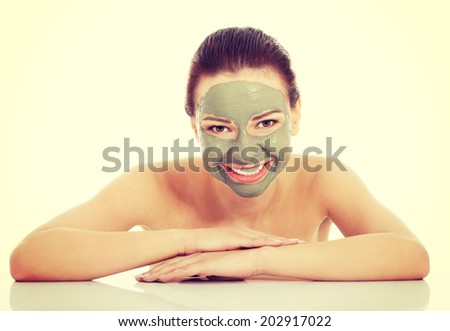 Beautiful woman with green clay facial mask