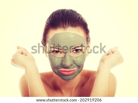 Beautiful woman with green clay facial mask
