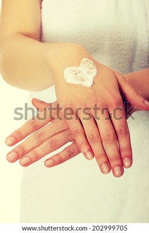 Woman with heart shape cream on hand. Over white.