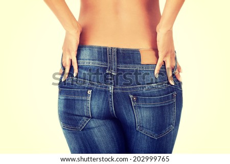 A young sexy woman is wearing blue jeans. Rear view.