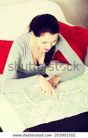 Young woman is searching something in map.
