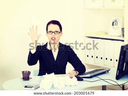 Stressed business woman is working with documents in office.