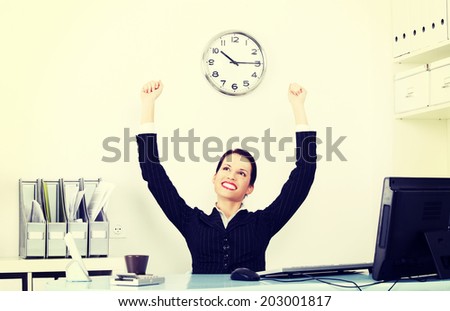 Beautiful business woman rise her hands up. She is happy and satisfacted. Success in work concept.