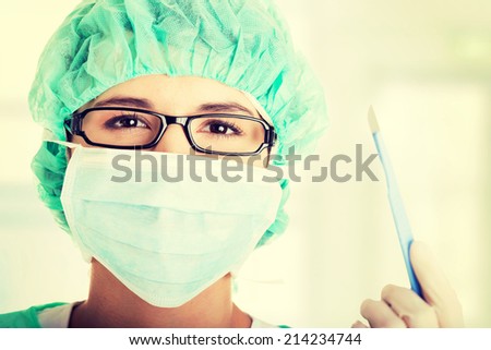 Portrait of happy young woman doctor or nurse with surgical mask and cap