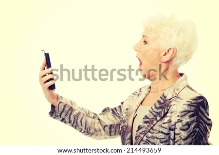 An old elegant lady using mobile phone. Isolated on white.