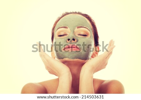 Beautifu toplessl woman with facial mask having her eyes closed. Isolated on white.