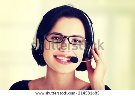 Closeup of attractive customer support representative smiling with headset on white background