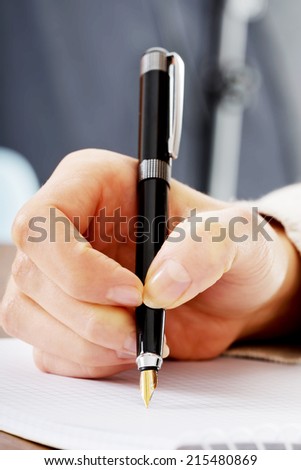 Handwriting, hand  writes with a pen in a notebook