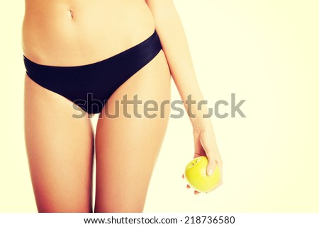 Beautiful fit sensual female body and apple isolated on white background