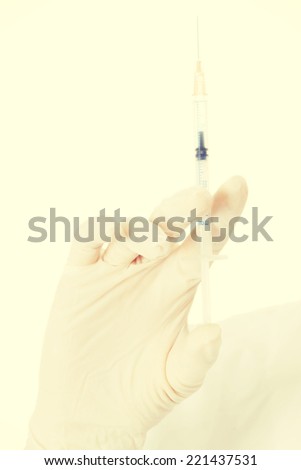 Woman's hand in sterile glove and needle. Isolated on white.