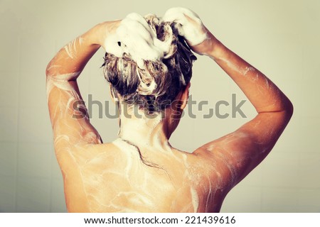 Woman taking a shower and shampooing her hair